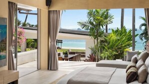A bedroom with a large bed, a view of the beach, and a dining area with outdoor seating. - Best Family Beachfront Villa Koh Samui |Chef| Staff|JetSkis|Pool|No Hidden Fees| (koh samu)