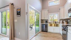 A modern kitchen with white cabinets, a stainless steel dishwasher, and a built-in oven.
