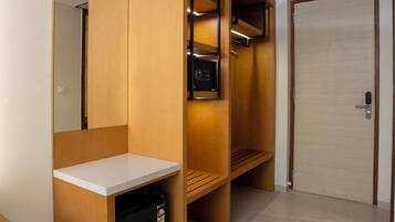 A modern bathroom with a wooden vanity, a mirror, and a towel rack.