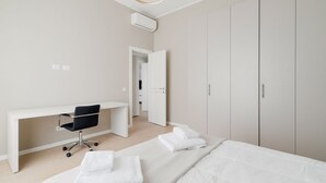 A modern bedroom with a bed, a desk, and a wardrobe. - GuestHost - Bright apartment of about 85 sqm, able to accommodate up to 5 people, located on the mezzanine floor of a building (NO elevator - there are some steps to climb).The property is located in a residential area of ​​Milan, full of services an (Milan)