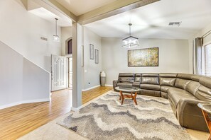 Relax in this stylish living area with a large L-shaped sofa and contemporary light fixture.