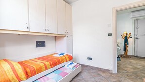 A small room with a bed, a wardrobe, and a door leading to another room. - La Rosa dei Venti (Sorso)