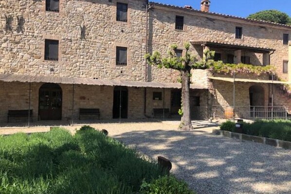 Un edificio de piedra con varias ventanas y un patio central.