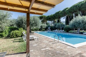 A swimming pool with lounge chairs, a pergola, and surrounding greenery. - GuestHost - Cosy flat equipped with all comforts to comfortably accommodate up to 3 people. The accommodation is located in a renovated former oil mill, which offers its guests numerous shared facilities: access to the seasonal swimming pool, green area  (Passignano)