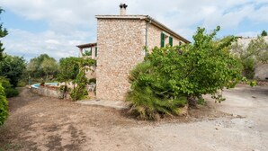 A stone building with a small pool, surrounded by greenery and trees. - Ses Roques in Santa Maria del Cam (Santa Maria del Camí)
