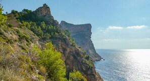 A coastal cliff with rocky terrain and sparse vegetation. - Marina Bay II in Bah a de J vea (Javea)