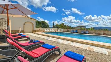 Relax by the serene pool surrounded by lounge chairs and a shaded area.
