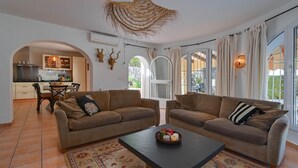 Ένα σαλόνι με δύο καναπέδες, ένα τραπεζάκι σαλονιού και μια τραπεζαρία με καρέκλες και ένα τραπέζι.