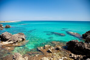 A coastal landscape with clear turquoise waters and rocky formations. - Bilocale Melograno Among Greenery And Sea (Otranto)