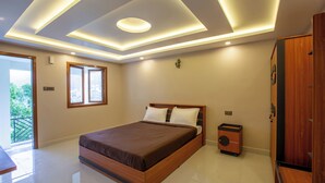 Een moderne slaapkamer met een groot bed, inbouwtafeltjes en een plafond met inbouwspots.