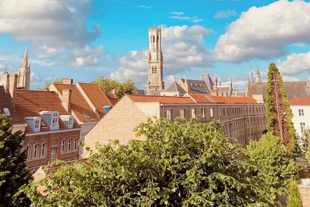 A historic town with a prominent clock tower, traditional buildings, and a clear blue sky.