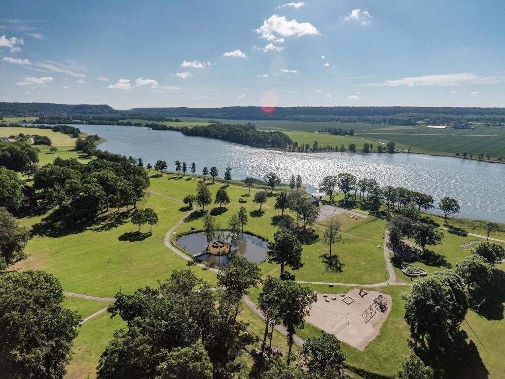 Vista aérea de un parque con un lago, senderos y un estanque pequeño.