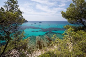 A coastal landscape with clear turquoise waters, boats, and pine trees. - Emperador in Benissa (Benissa)