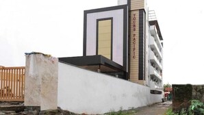 Un bâtiment moderne à la façade blanche, doté d’une enseigne verticale bien visible indiquant « YOURS PACIFIC », et d’un toit plat.