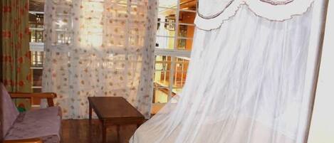 A room with a bed, a wooden table, and a chair.