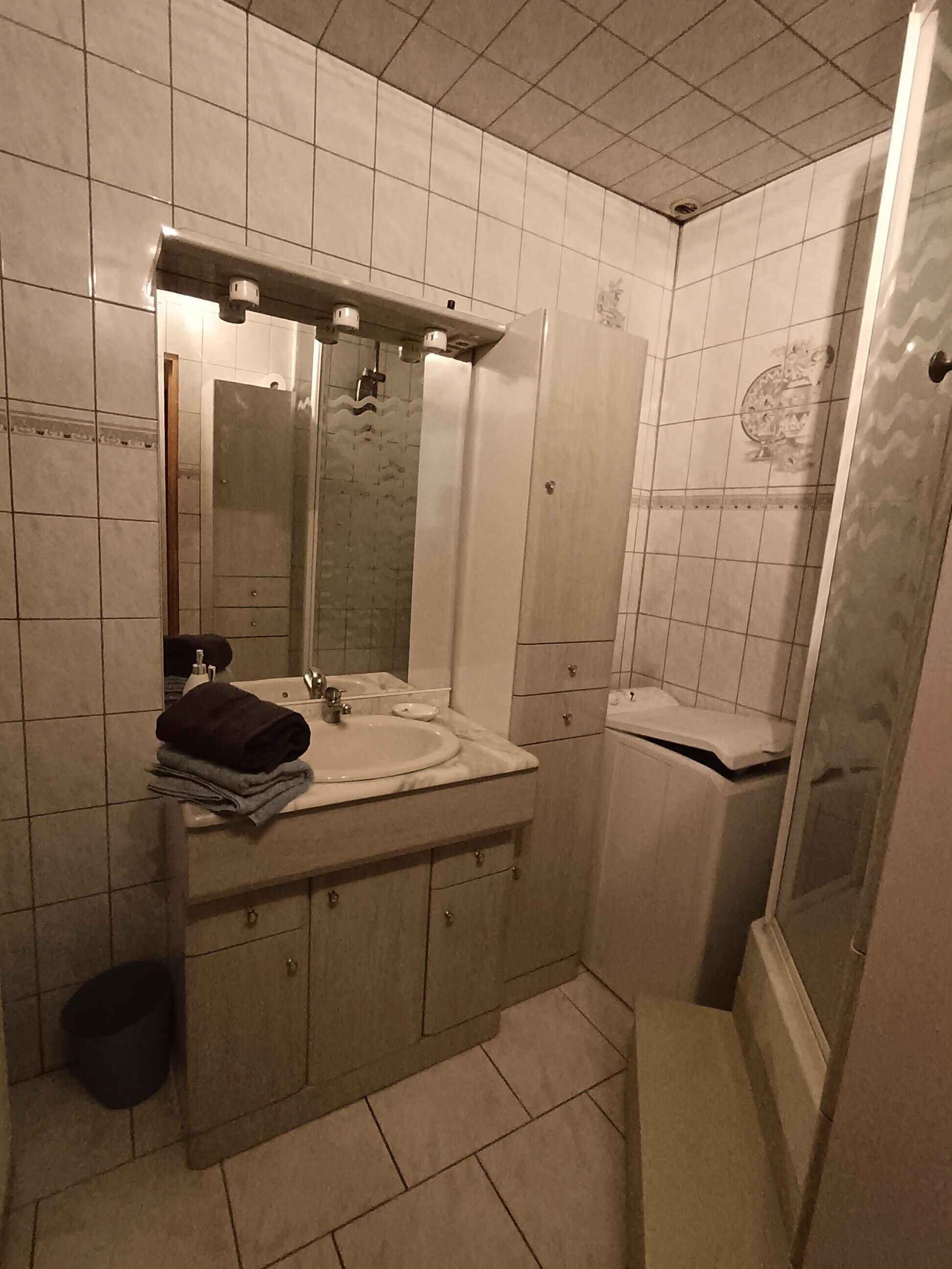 Un baño con lavamanos, espejo y ducha.
