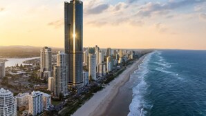 A coastal cityscape with high-rise buildings, a beach, and a view of the ocean.