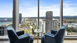 A high-rise room with a large window overlooking a cityscape.