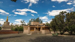 A traditional building with a distinct architectural style, a small shrine, and a seating area. - Chulli Bagh Villa  (Leh)