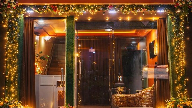 L'ingresso dell'Hotel Shivoham, con tappeto rosso, decorazioni floreali e un cartello sopra l'entrata.