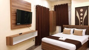 Camera d'albergo moderna con un letto di legno, una TV a parete e una mensola a incasso.