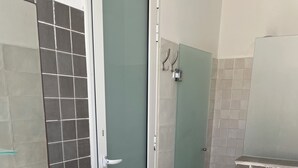 Et badeværelse med en hvid vask, trækommode og toilet.