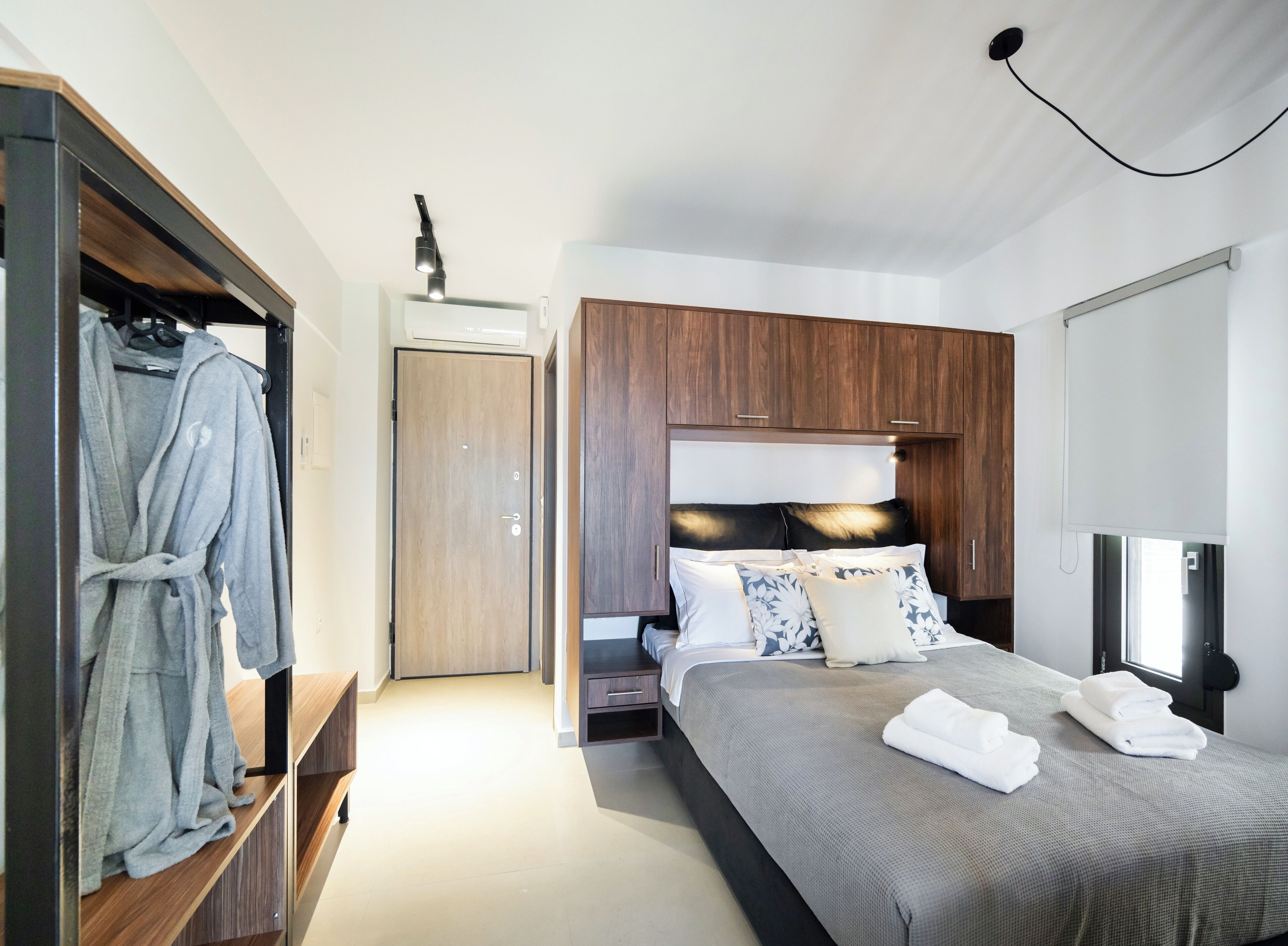 Ein modernes Schlafzimmer mit Bett, Schrank und Nachttisch.