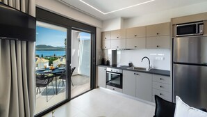 Eine moderne Küche mit Meerblick, ein Essbereich mit Tisch und Stühlen sowie eine große Schiebeglasdoor.
