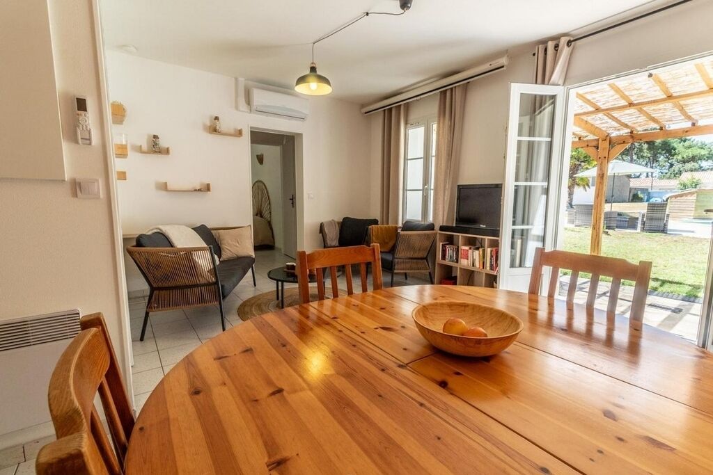 Un salon chaleureux avec une table à manger en bois, un téléviseur et un coin salon confortable.