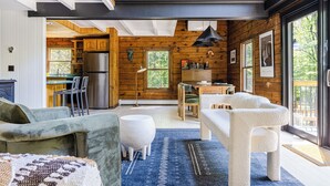 A modern interior with a kitchen, dining area, and seating space. - Pool & Hot Tub, Close to Hiking, Shops & Dining | Cragswood Lodge by AvantStay (Hudson Valley)