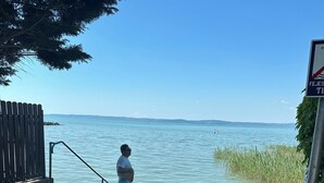 Une personne se tient au bord d’une plateforme en béton, surplombant une étendue d’eau.