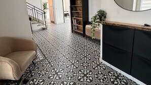 Een modern interieur met patroon vloerbedekking, een bank, een boekenkast en een spiegel.