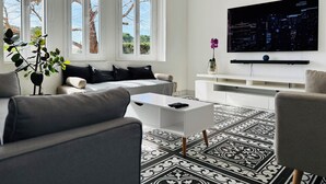 Een moderne woonkamer met een bank, salontafel en televisie.