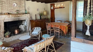 Un interior rústico con chimenea, muebles de madera y zona de comedor.