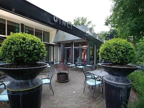 Relax in the OINC's outdoor seating area, surrounded by lush greenery and a cozy fire pit.