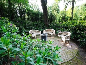 Sit and unwind in a serene garden setting surrounded by lush greenery and a tranquil seating area.