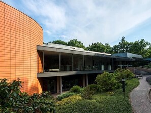 Stunning building with a curved brick facade and glass extension, set amidst a well-maintained environment.