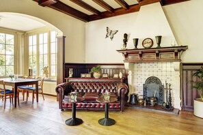 Relax in a traditional room with a high ceiling, exposed beams, and a cozy fireplace.