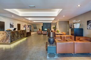 Experience the hotel's elegant lobby, featuring a spacious reception area with a seating area and artworks.