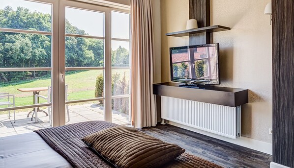 Relax in a serene space with a comfortable bed, flat-screen TV, and outdoor access.