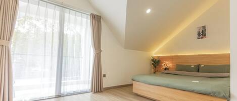 A modern bedroom with a built-in bed, large windows with curtains, and recessed ceiling lighting.