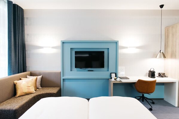 Relax in a stylish space with a comfortable sofa, flat-screen TV, and desk for work or leisure.