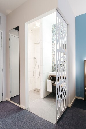 Bathroom features a walk-in shower with a glass door and mosaic tiles.