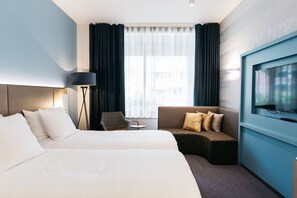 Relax in this serene space with two beds, a sofa, and a flat-screen TV.