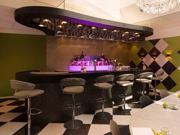 Enjoy a drink at the bar, surrounded by a geometric pattern and modern decor.