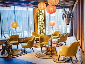 Relax in a stylish lounge area with comfortable armchairs, a glass coffee table, and a unique rug.
