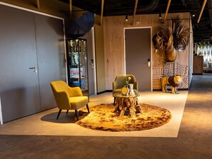 Relax in this serene space with a round table, two comfortable armchairs, and a lush potted plant.