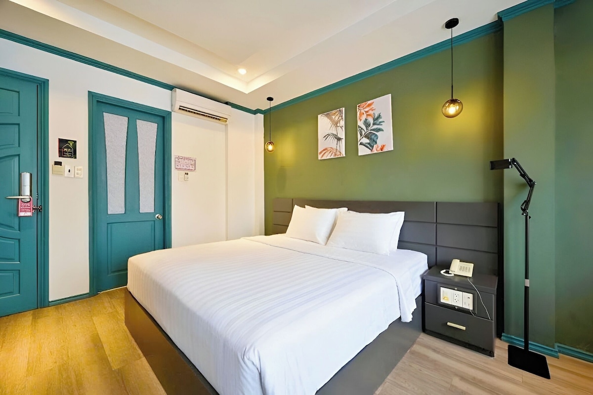 Un dormitorio ordenado con cama, mesita de noche y lámpara.