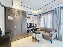 Una sala de estar moderna con un sofá, un televisor, una mesita y un armario.