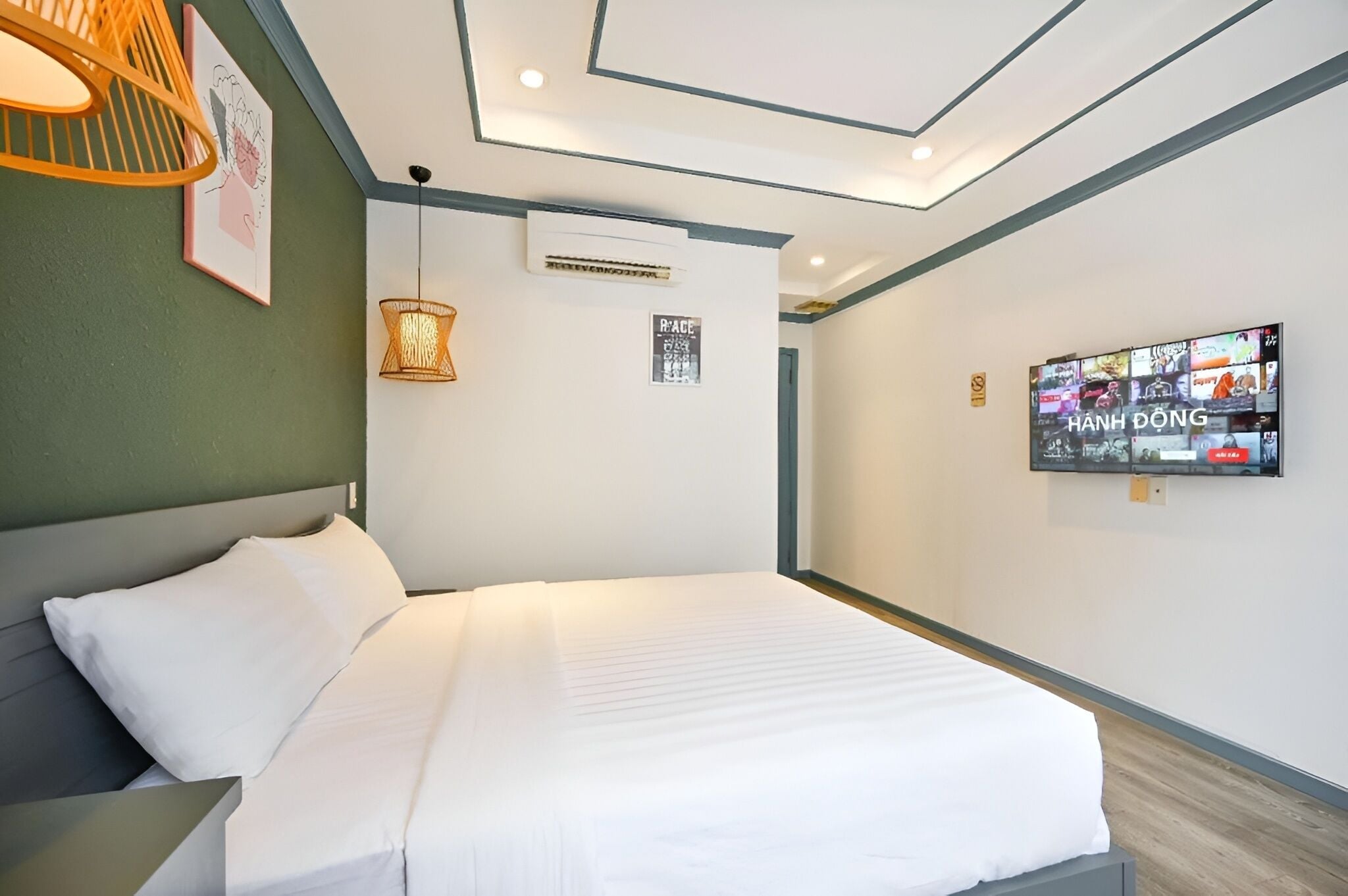 A hotel room with a bed, a wall-mounted TV, and a ceiling light fixture.